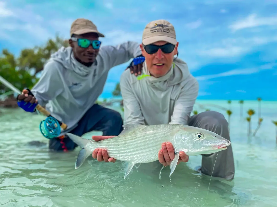 Fly angler releasing a permit caught on fly on the flats in Roatan Honduras
