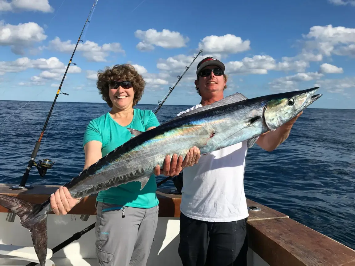 Angler holding a large wahoo caught deep sea fishing offshore from Roatan Honduras